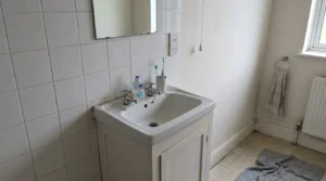 Bathroom vanity unit at standard height with a basin and mirror.