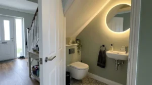 Compact under-stairs cloakroom with wall-hung WC and basin.