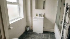Bathroom with large wall tiles and a practical floor tile.